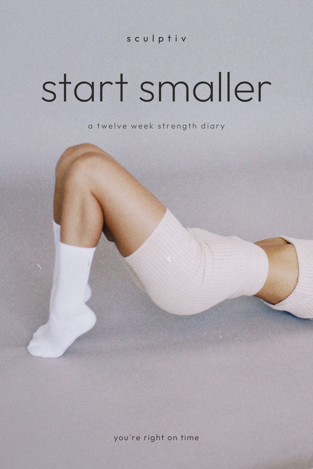 start smaller: a twelve week strength diary. Paperback cover with a woman lying on a grey studio floor in a white set.